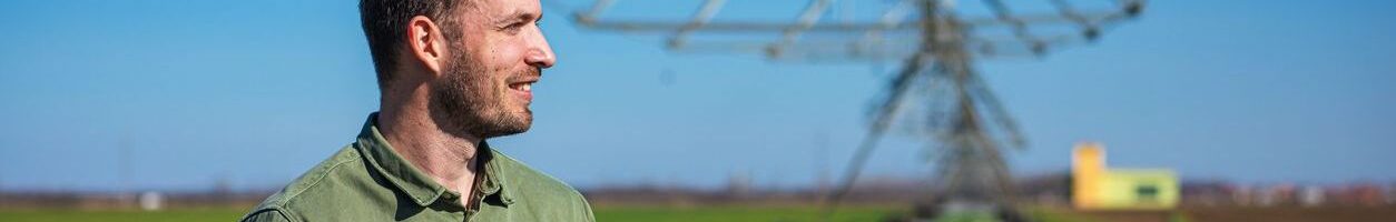 Young farmer standing in wheat field and setup irrigation system on tablet.